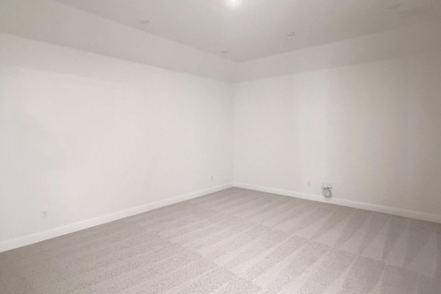Spare room with light colored carpet and baseboards