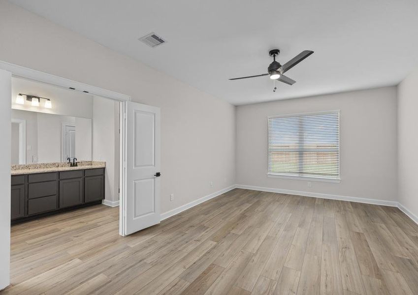 The master bedroom has plank flooring and a ceiling fan.