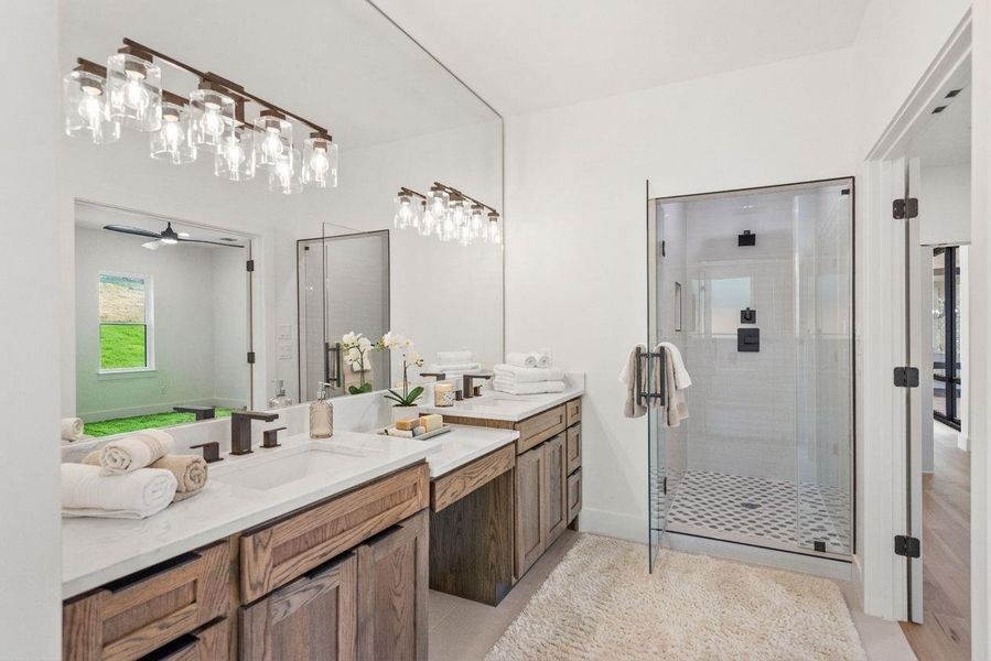 Spacious primary bathroom featuring dual vanities, custom white oak cabinetry, stunning quartz countertops, and a generously sized walk-in shower.