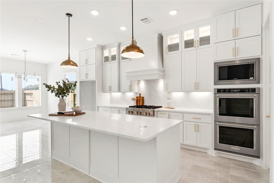 This chef-inspired kitchen is anchored by a large quartz island , professional double ovens, and warm pendant lighting, creating the ultimate space for both casual meals and elevated entertaining.