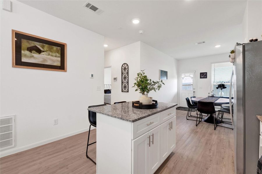 Fall in love with a modern chef’s kitchen featuring stainless-steel appliances, sleek cabinetry, ample counter space, and a large breakfast bar, creating a perfect balance of beauty and functionality.