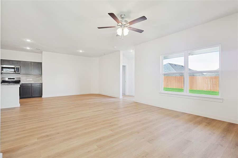 Unfurnished living room with ceiling fan and light hardwood / wood-style flooring