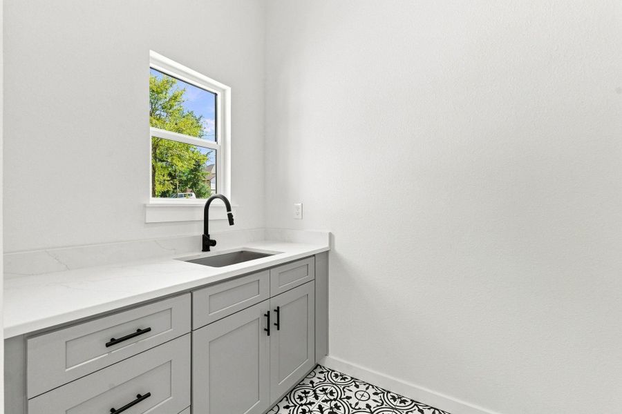 Laundry room - Eye-catching black and white geometric patterned tile creates an upscale boutique look.
