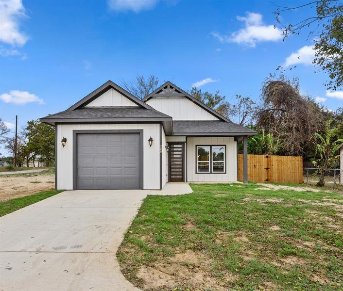 View of front of home featuring roof with shingles, concrete driveway, an attached garage, and a gate View of front of home featuring roof with shingles, concrete driveway, an attached garage, and a gate