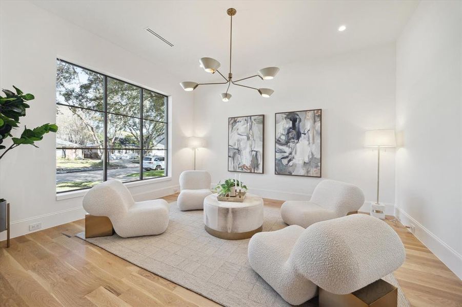 The front living room/parlor is filled with natural light and offers a brass chandelier and view of the front yard.