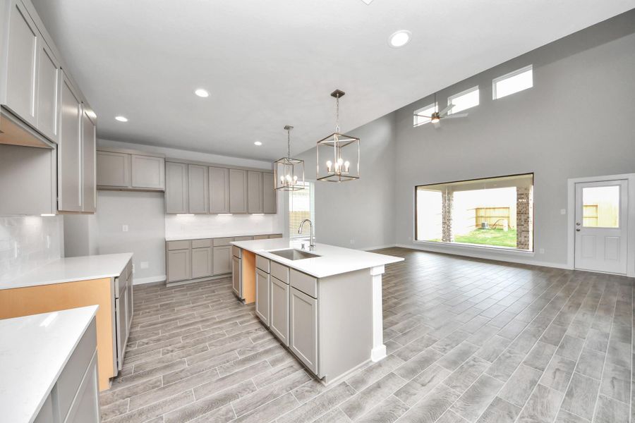 The kitchen is a culinary haven, featuring granite countertops, a tile backsplash, stainless steel appliances, 42” upper cabinets, and undercabinet lighting.