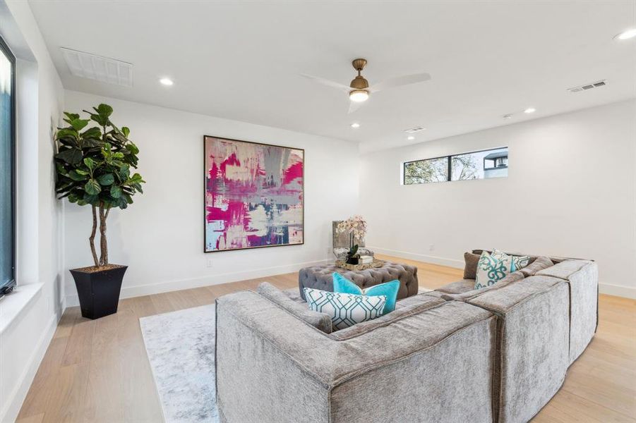 Additional living area with warm wood floors and flexible layout, perfect for a media room, playroom, or lounge.