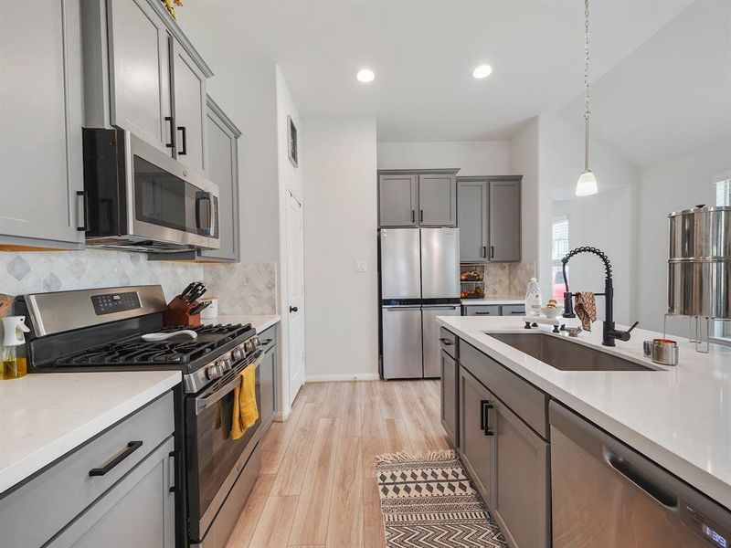 Stainless appliances bejewel this kitchen and a gas stove! The kitchen faucet is upgraded with brand new pulls on cabinetry and look at the lovely backsplash.