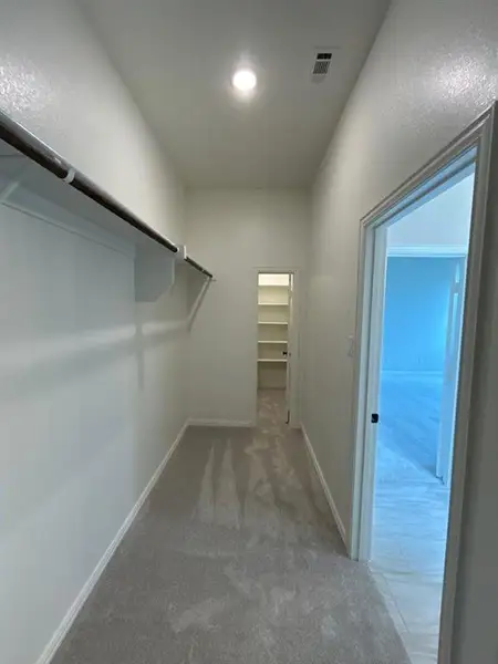 Hallway featuring light grey carpeting, white painted walls, and an overhead recessed light