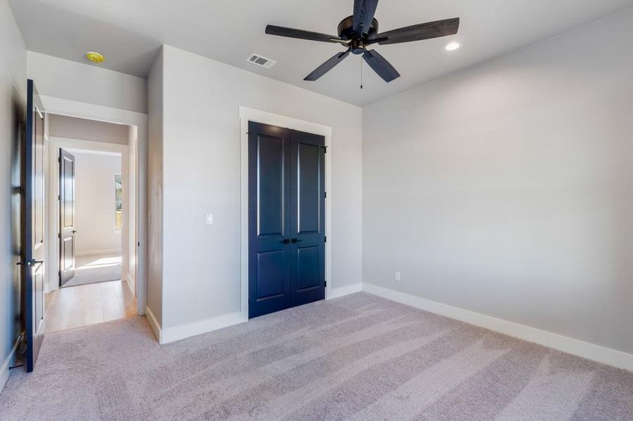 Unfurnished bedroom with light carpet, a closet, and ceiling fan