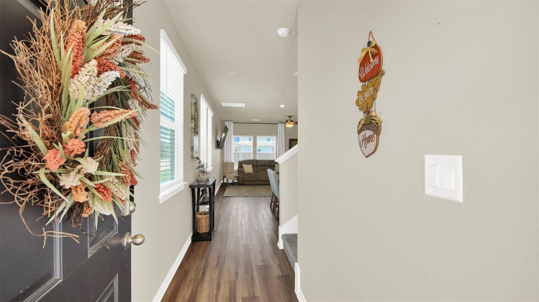 Entryway featuring wood-finish flooring, a neutral color palette, and multiple windows with blinds