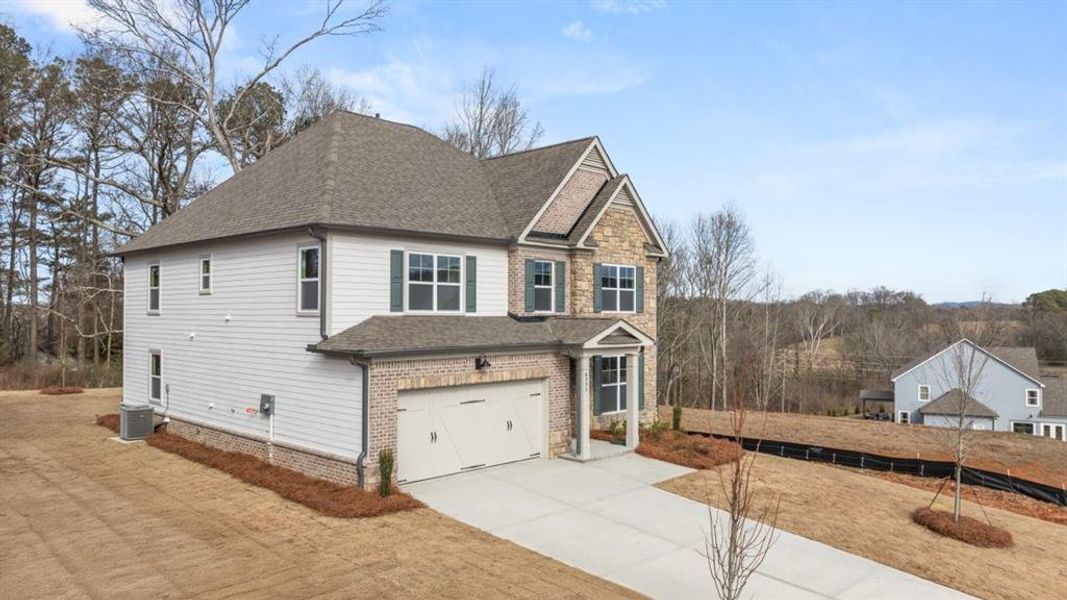 Front exterior of a new home in Holland Estates, Powder Springs, GA, highlighting curb appeal (Image 2). Front exterior of a new home in Holland Estates, Powder Springs, GA, highlighting curb appeal (Image 2).