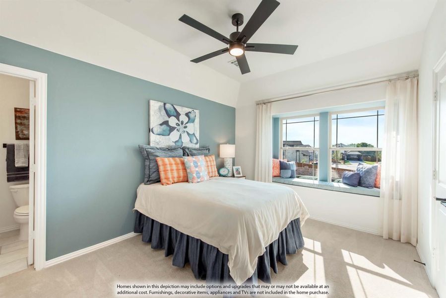 Bedroom with blue accent wall, ceiling fan, window seat, and ensuite bathroom access