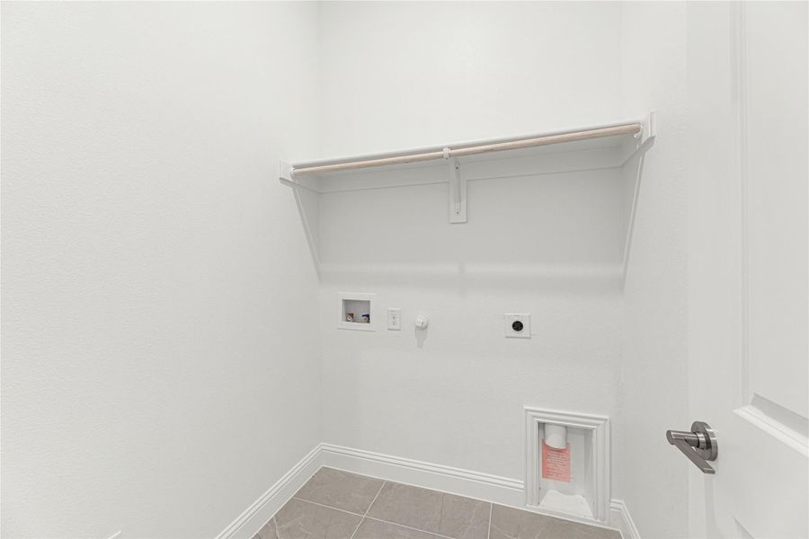 Laundry room with wall-mounted shelf, hanging rod, washer and dryer hookups, and tile floor Laundry room with wall-mounted shelf, hanging rod, washer and dryer hookups, and tile floor