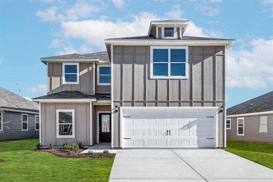 View of front of house featuring a garage and a front lawn