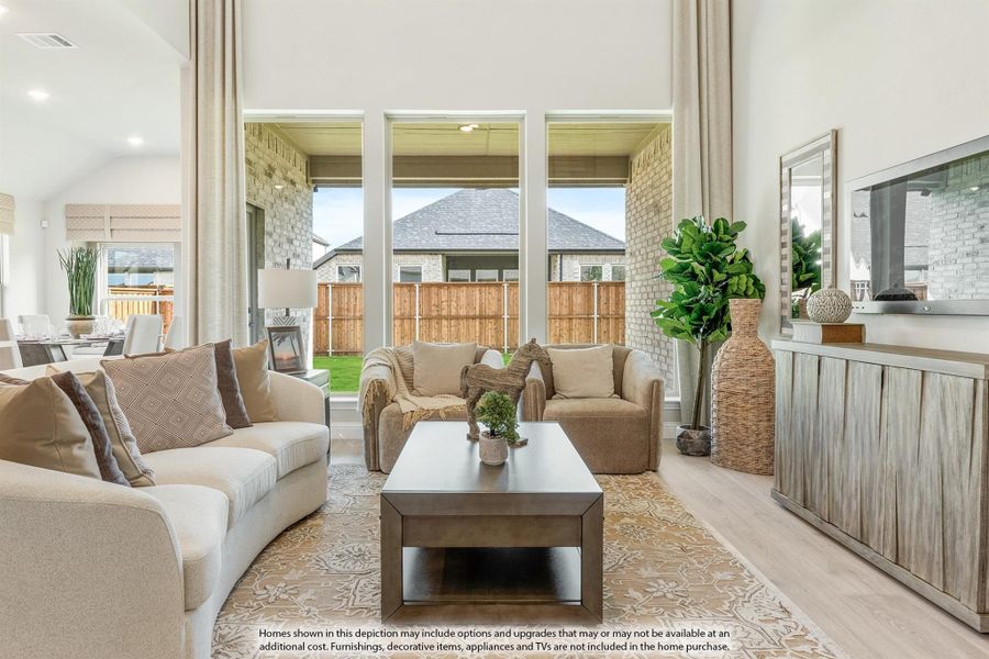 Open living room with high ceilings, large windows, neutral sofas, and wood coffee table on patterned rug Open living room with high ceilings, large windows, neutral sofas, and wood coffee table on patterned rug