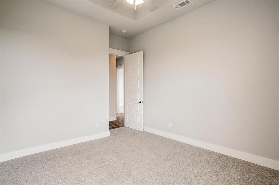 Unfurnished room featuring ceiling fan and carpet flooring