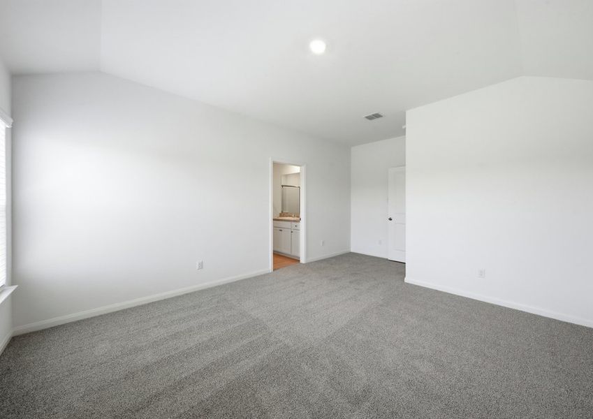 Primary bedroom featuring carpet flooring and a doorway to the ensuite master bath. Primary bedroom featuring carpet flooring and a doorway to the ensuite master bath.