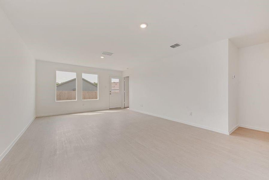 Empty room with light wood finished floors and recessed lighting