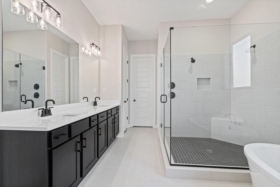 Bathroom featuring double vanity, a freestanding bath, and a stall shower