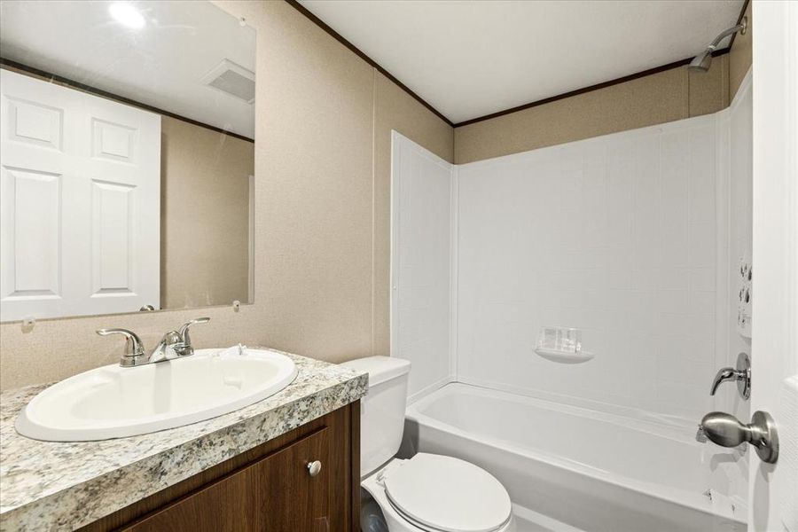Bathroom featuring a vanity with an integrated sink, laminate countertop, and wood-finish cabinetry