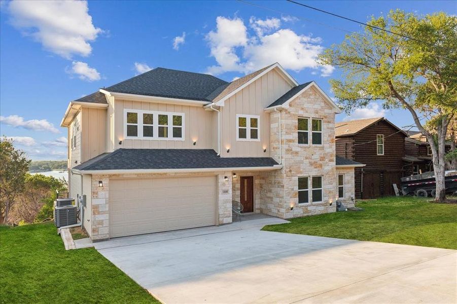 View of front of property featuring a garage, a front yard, and cooling unit