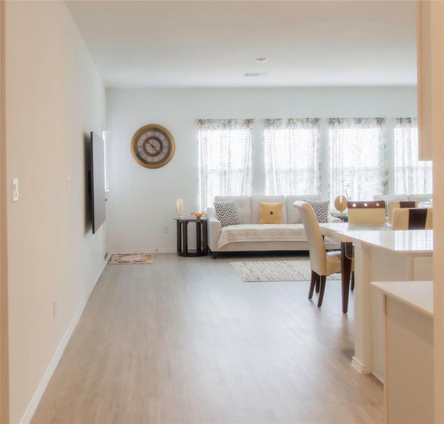 Spacious living room showcasing light wood-style floors and recessed lighting, ideal for everyday living and entertaining.