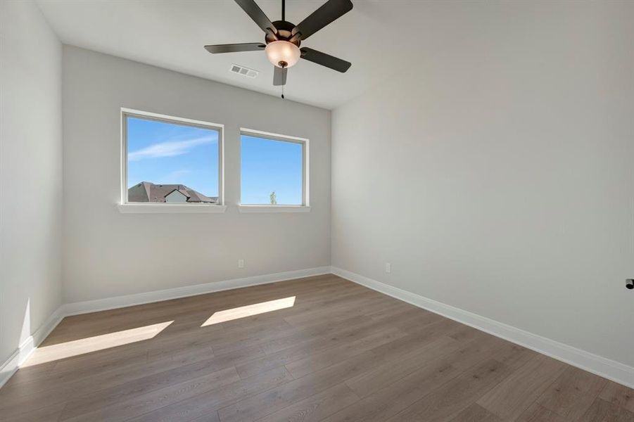 Unfurnished room with dark wood-style flooring and ceiling fan