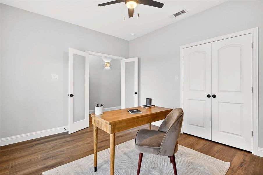 Home office with dark wood-style floors and french doors