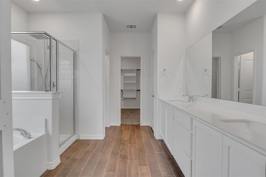 Master Bathroom with dual vanity, hardwood / wood-style floors, and independent shower and bath