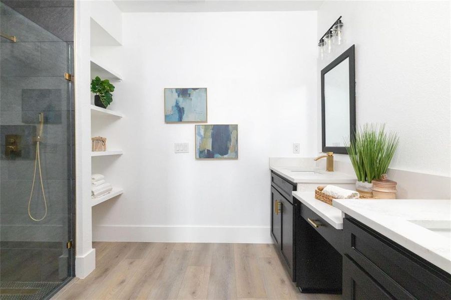 Bathroom with hardwood / wood-style floors, vanity, and a shower with door