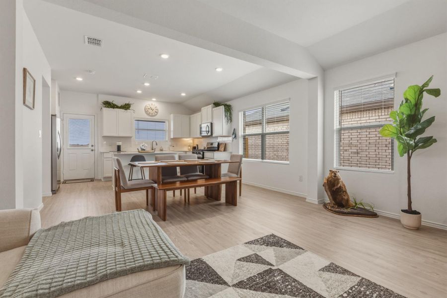 The open-concept design integrates the kitchen and living areas, featuring light-colored flooring throughout