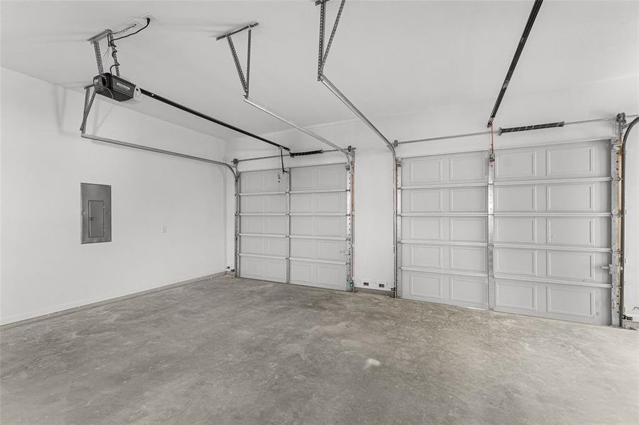 Garage featuring electric panel and a garage door opener
