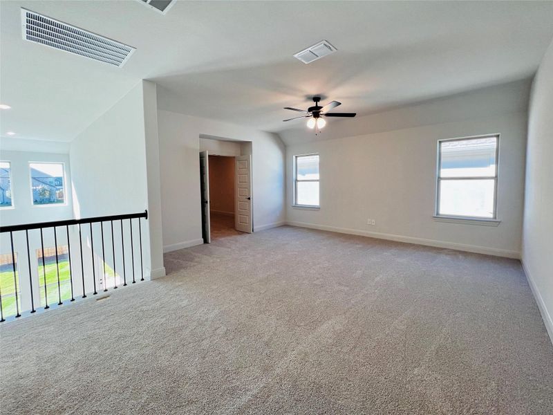 Unfurnished room with ceiling fan and light colored carpet
