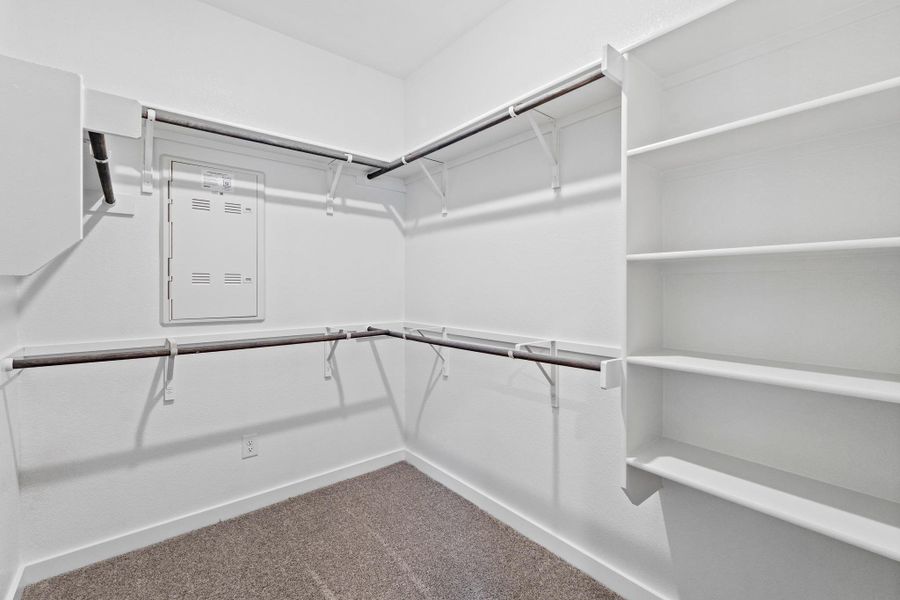 Well-organized walk-in closet with ample shelving and hanging space.