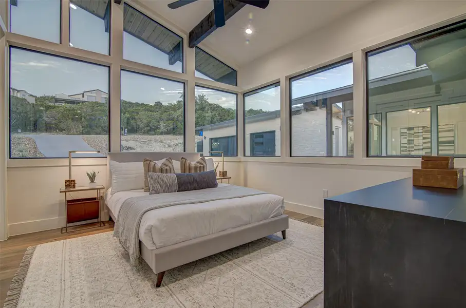 Bedroom with baseboards, wood finished floors, and a ceiling fan Bedroom with baseboards, wood finished floors, and a ceiling fan