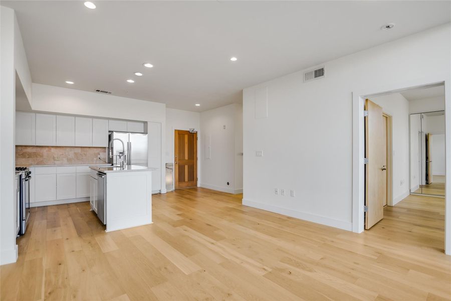 Kitchen/Dining & Living Rm w/door to Master BR. 6" French White Oak flooring, custom built-in storage baseboards & trim throughout.