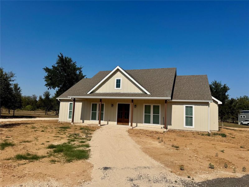 View of front of property featuring a shingled roof and a porch View of front of property featuring a shingled roof and a porch