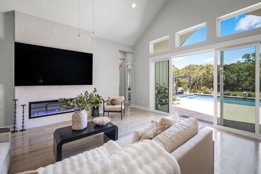 Step into a sun-filled living area featuring vaulted ceilings and seamless access to a refreshing pool.