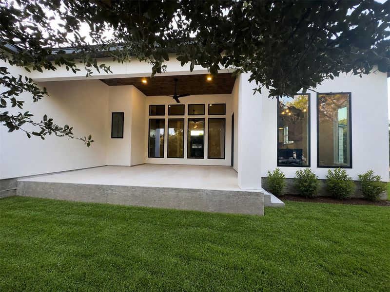 An inviting covered patio features a warm wood ceiling and clean concrete flooring. An inviting covered patio features a warm wood ceiling and clean concrete flooring.