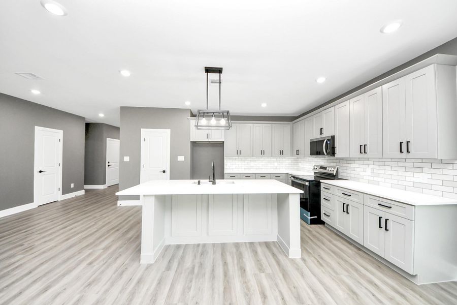 modern kitchen featuring ample cabinets, sleek counter tops, and an open flow into the main living space.