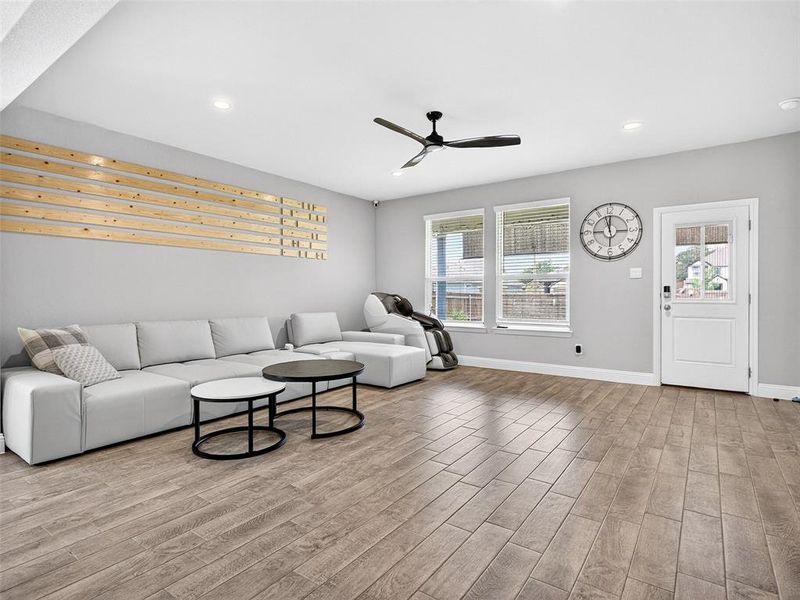 Spacious living area featuring wood-finish tile flooring and recessed lighting Spacious living area featuring wood-finish tile flooring and recessed lighting