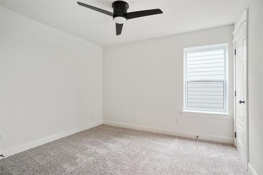 Unfurnished room with light colored carpet and a ceiling fan