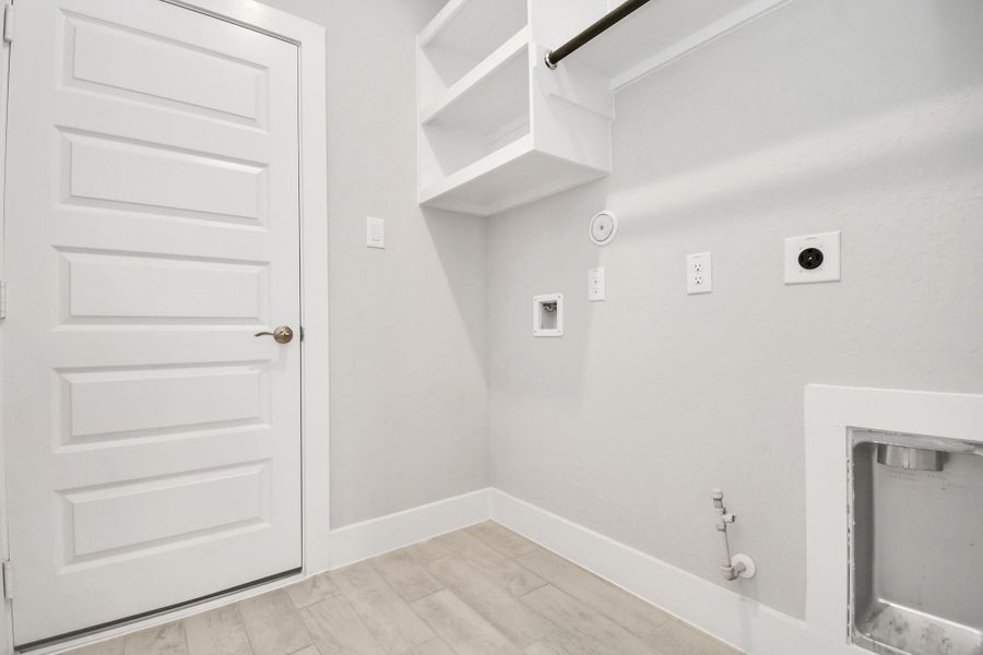 A perfect blend of functionality and comfort. Capture the essence of easy living with a first-floor laundry room, thoughtfully equipped with shelving for effortless organization. Both electric and gas connections available. Sample photo of completed home with similar floor plan. Actual colors and selections may vary. A perfect blend of functionality and comfort. Capture the essence of easy living with a first-floor laundry room, thoughtfully equipped with shelving for effortless organization. Both electric and gas connections available. Sample photo of completed home with similar floor plan. Actual colors and selections may vary.