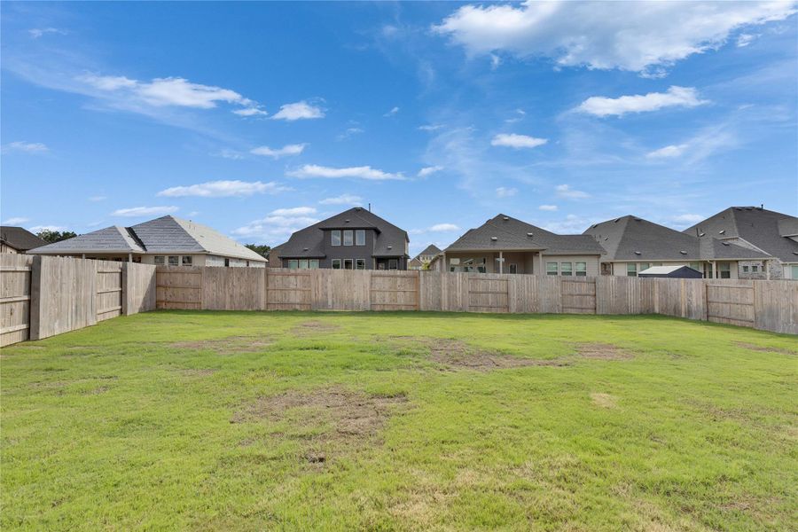 Fenced backyard with a residential view Fenced backyard with a residential view