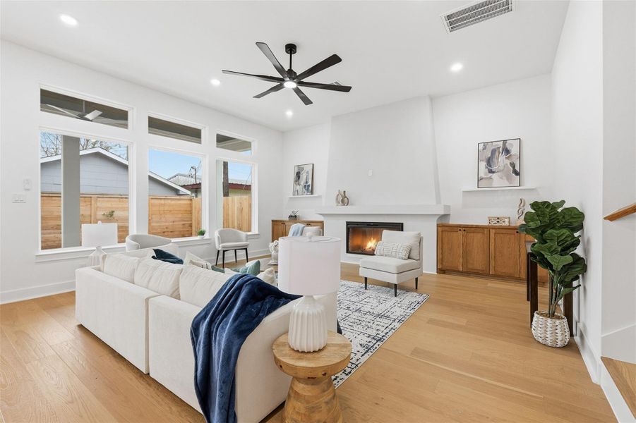 Rear-facing windows overlook the patio, filling the living room with natural light, while 11-foot ceilings and engineered hardwood flooring extend throughout the entire first level.