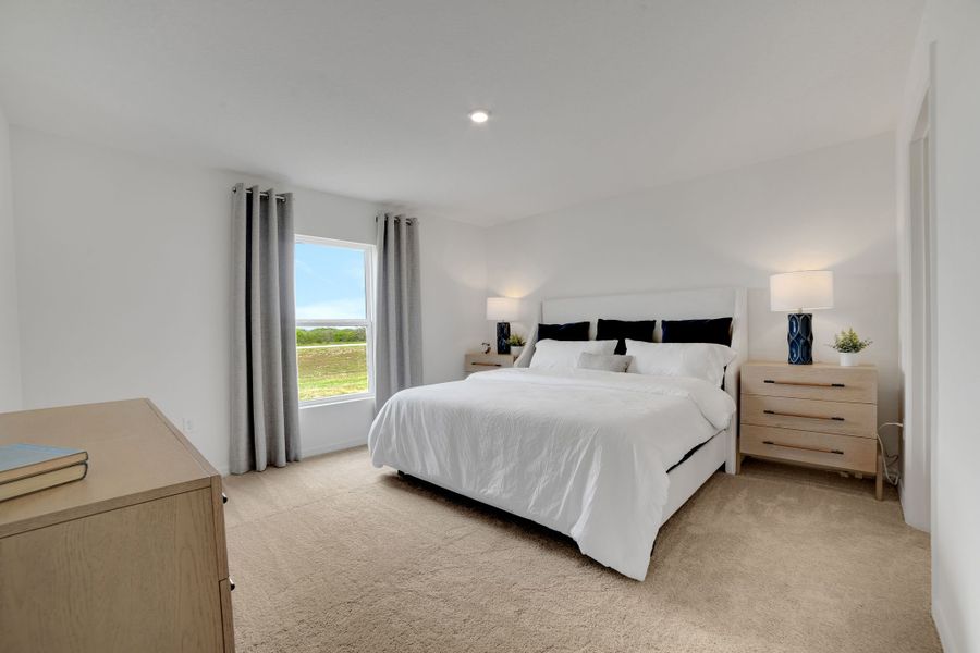 A bedroom with a large window.