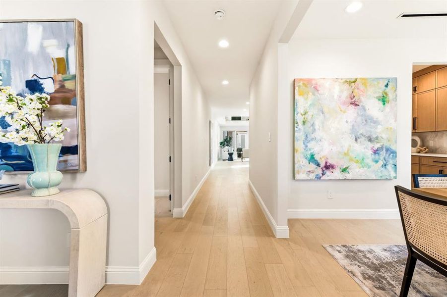 Hall with light wood finished floors and recessed lighting