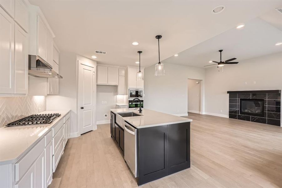 Kitchen featuring visible vents, a ceiling fan, appliances with stainless steel finishes, under cabinet range hood, and white cabinetry Kitchen featuring visible vents, a ceiling fan, appliances with stainless steel finishes, under cabinet range hood, and white cabinetry