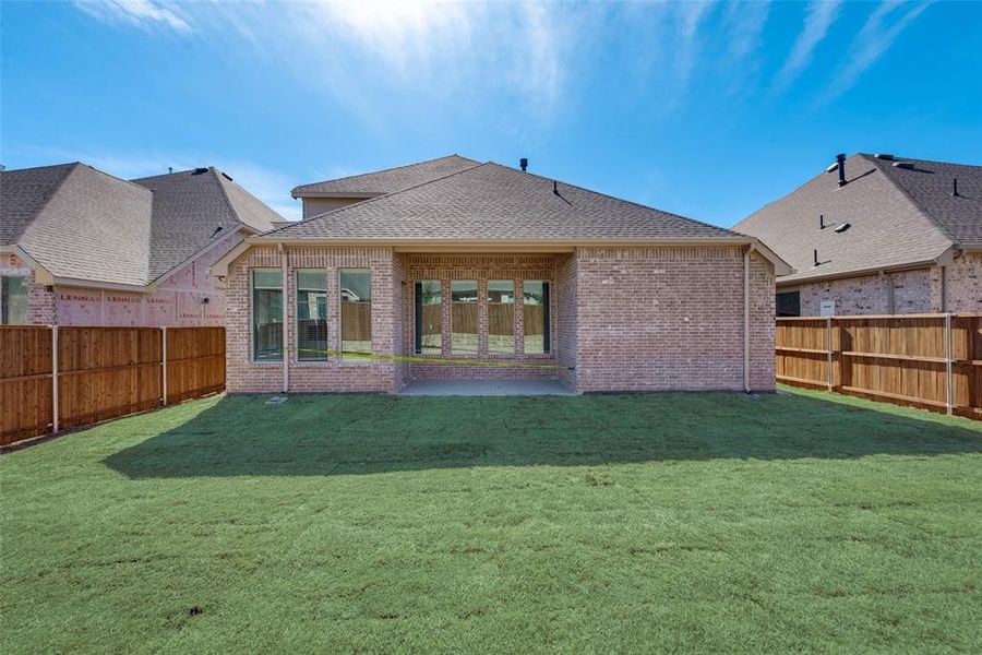 Back of house featuring a lawn and a patio area